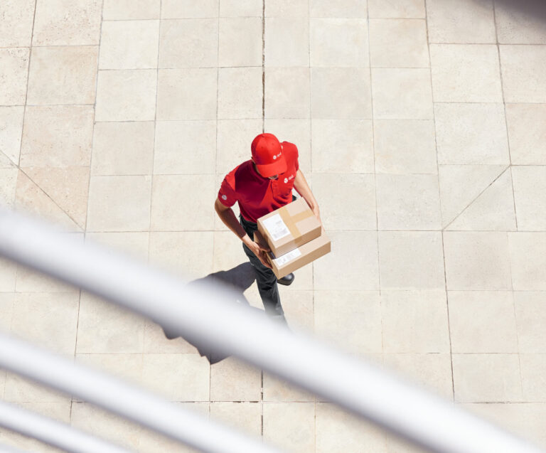 DPD delivery driver walking with two parcels