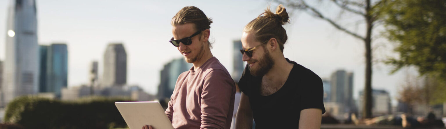 Men using laptop in park