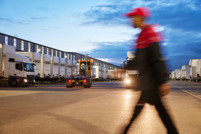 blurry shot of driver walking by depot outside during the night